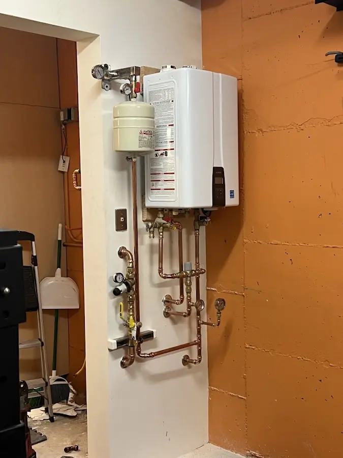 Plumbing technician inspecting water heater connections in Norwich